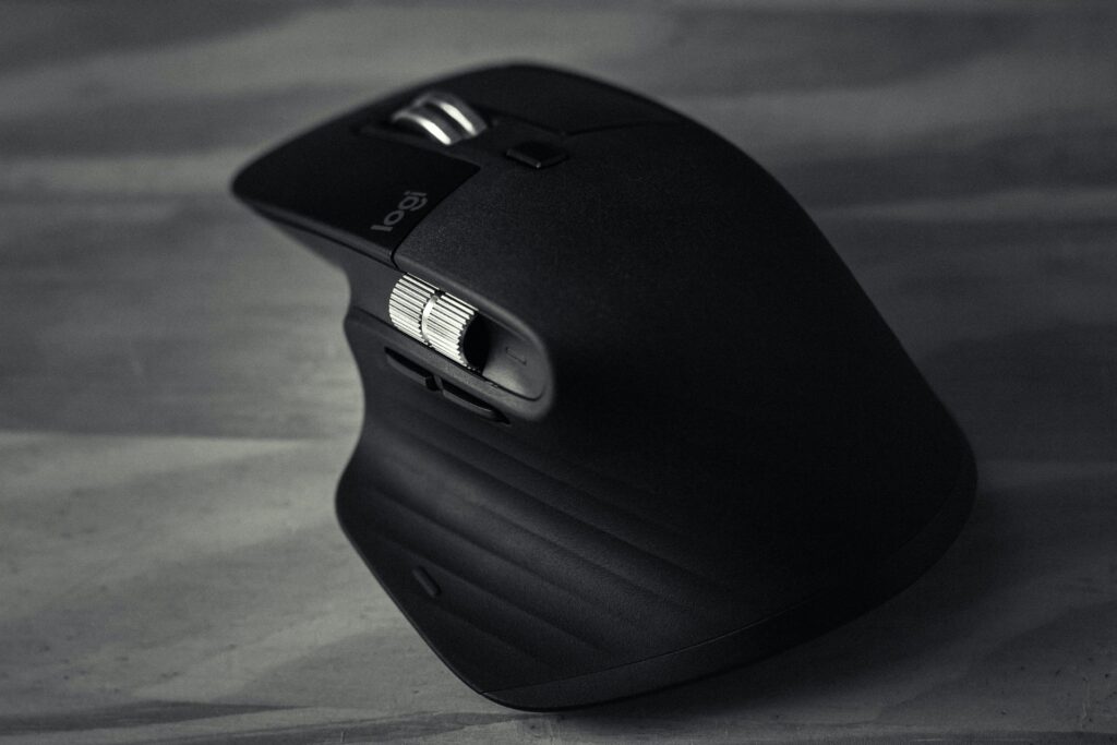 Black logitech mouse with palm grip design.