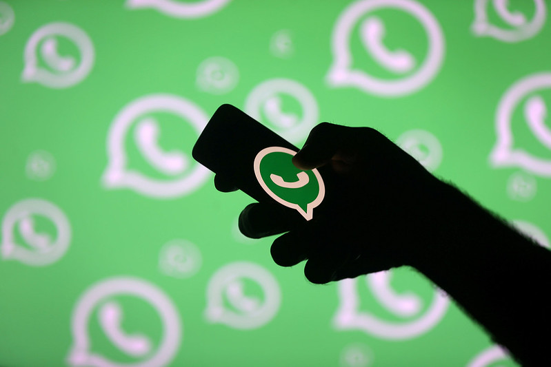 Whatsapp pay on phone with a background of whatsapp images.
